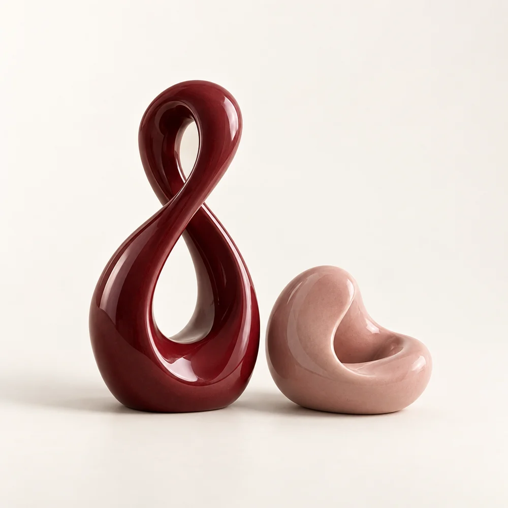 Dos esculturas de cerámica burdeos y rosa, cada una en su propio equilibrio